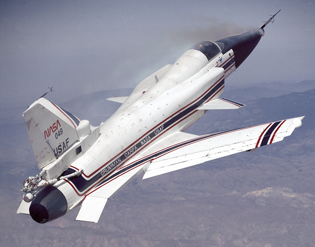 The second X-29, 82-0049, flown by NASA test pilot Rogers Smith, demonstrates the high angle of attack possible with the X-29. A smoke generator in the nose helps visualize airflow over the front of the aircraft. Note also the rescue parachute mounted above the engine exhaust nozzle. (NASA)